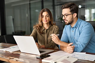 Two colleagues sat working on a laptop