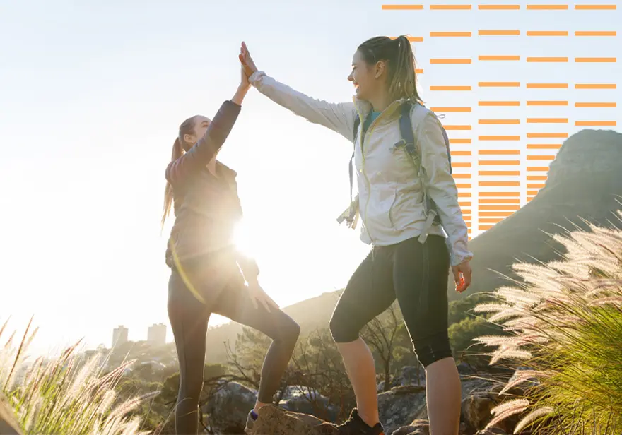 Two women walking doing a high five